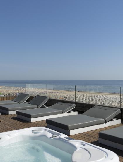 Terrazza con jacuzzi e lettini vista mare.