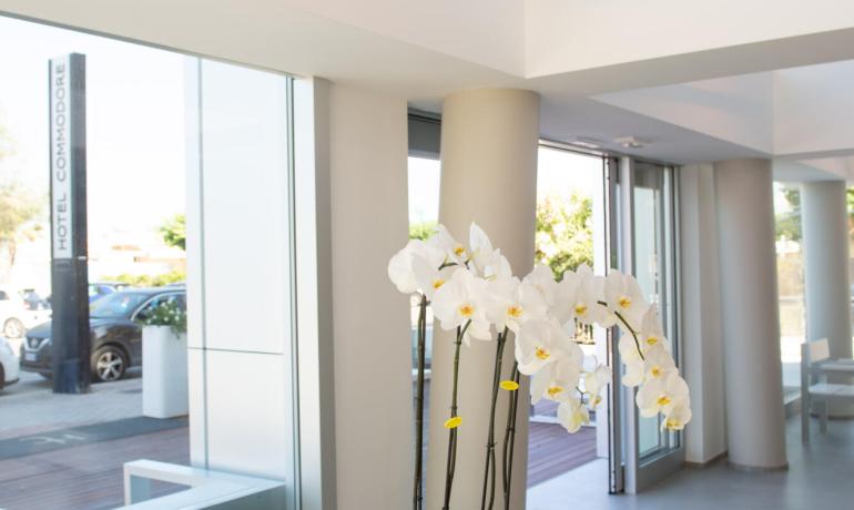Bright room with white table, orchids, and modern chandelier.