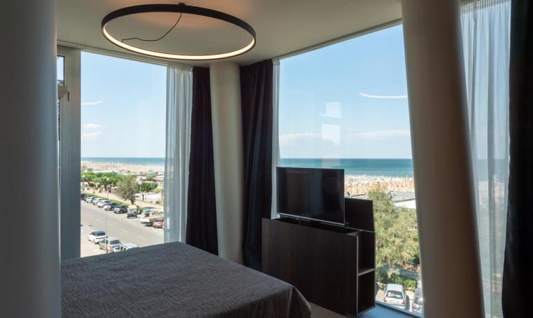 Modernes Zimmer mit Meerblick und großen Fenstern.