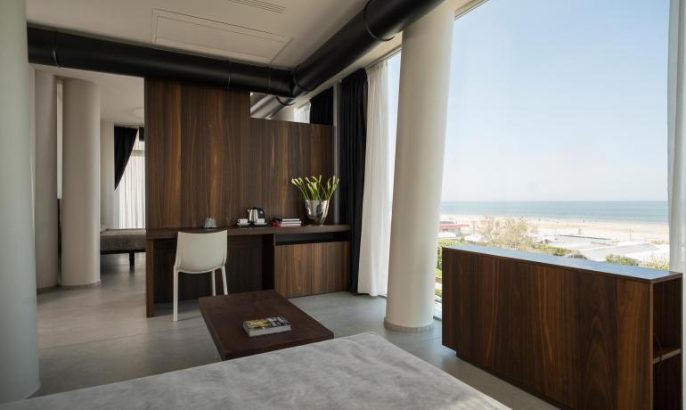 Stanza luminosa con vista mare, arredi moderni e atmosfera rilassante.