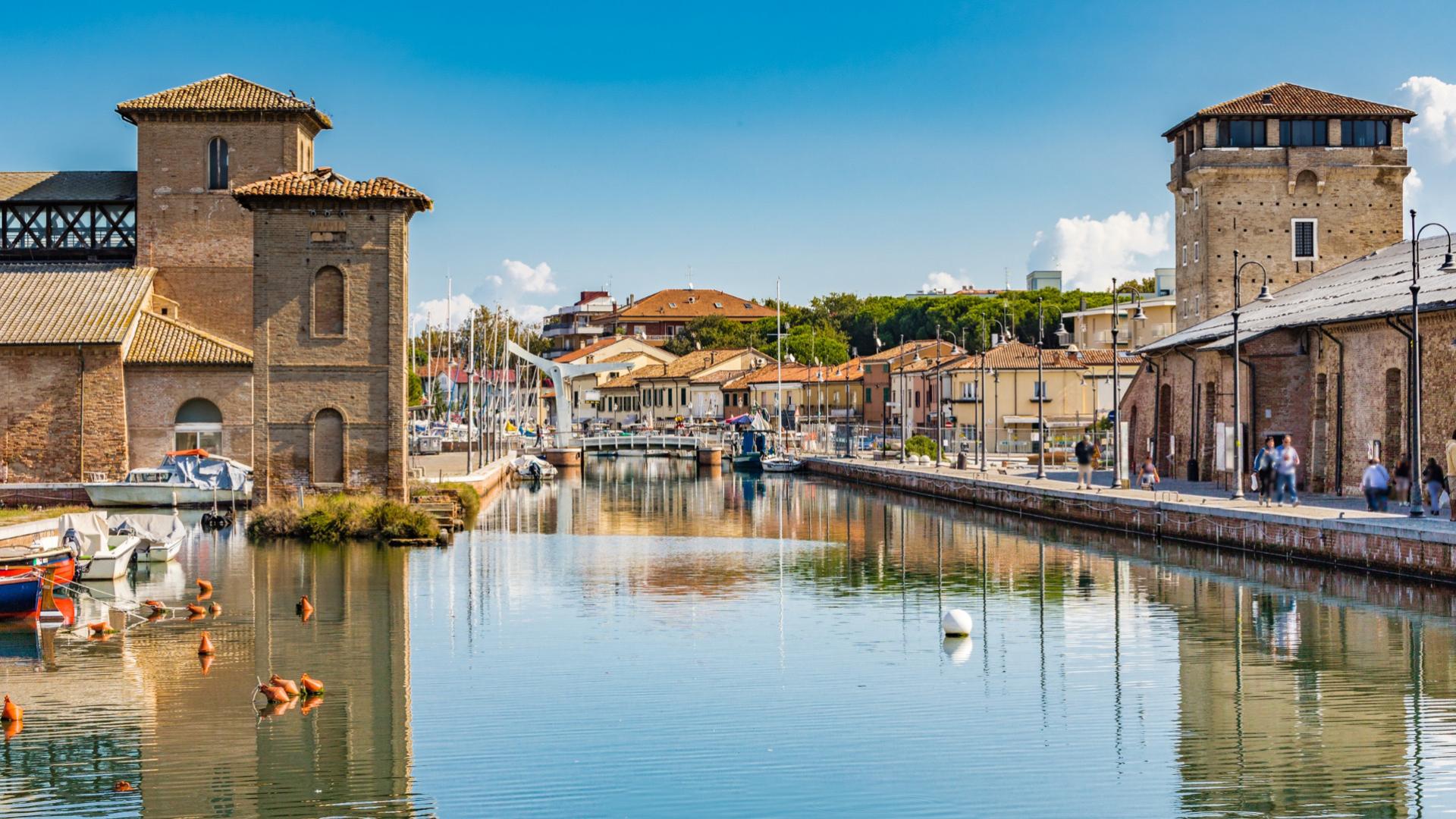 Canale con edifici storici e barche, atmosfera tranquilla e riflessi sull'acqua.