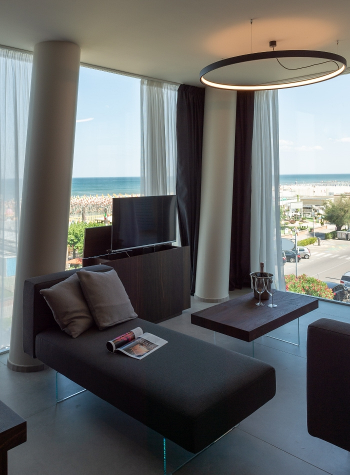 Salotto moderno con vista mare, arredi eleganti e ampie finestre.