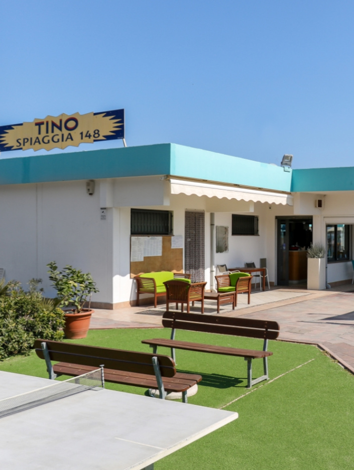 Spiaggia Tino 148 con area relax, panchine e tavolo da ping pong.